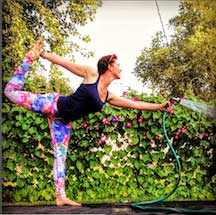 Ashley Rae Swanson in a yoga pose while watering flowers