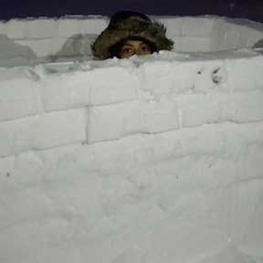 Daisy Lopez hiding behind a snow fort