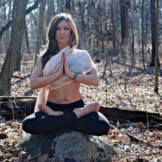 Victoria Rowell in a yoga pose in the woods
